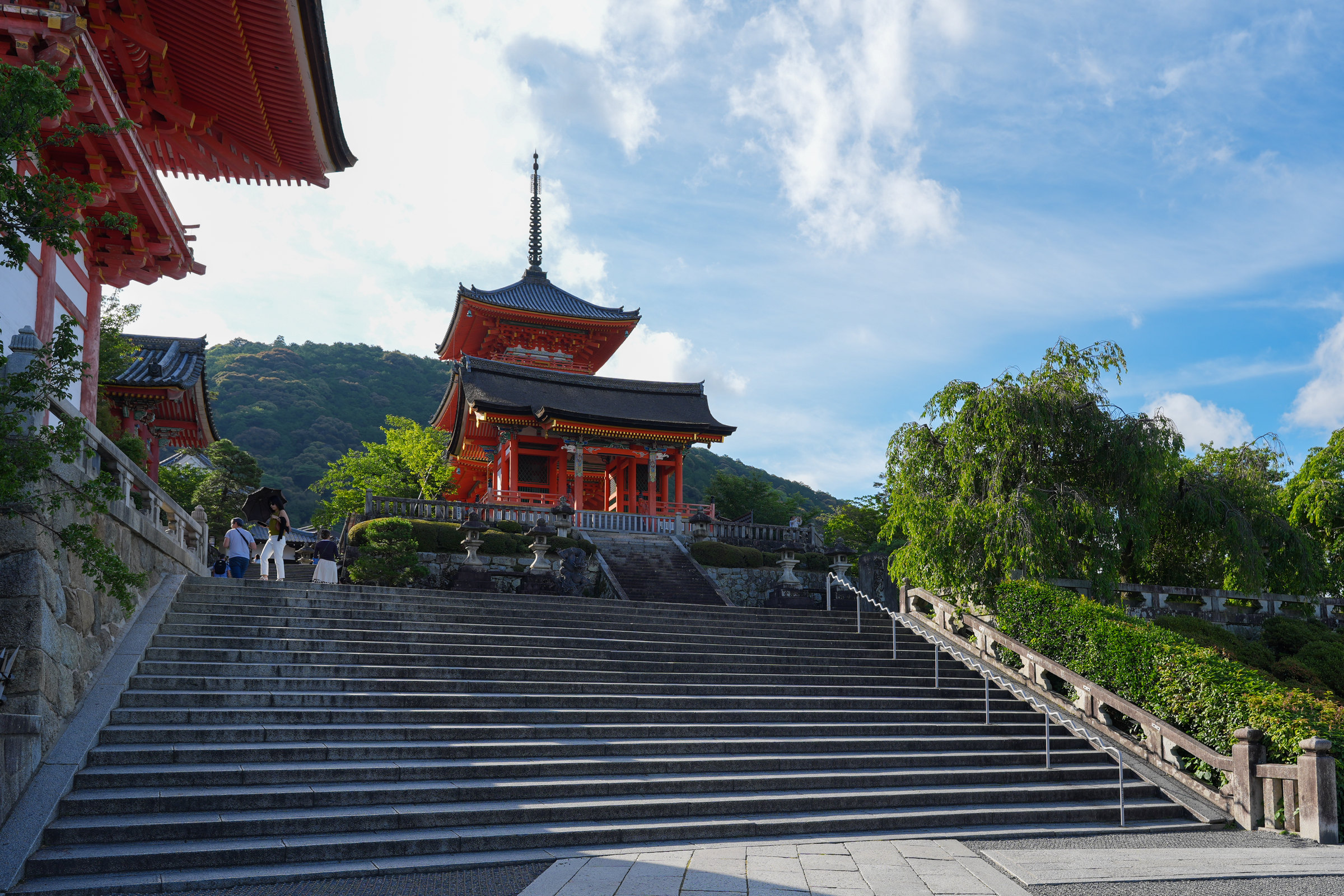 Broad stone steps rising to a vermilion temple building