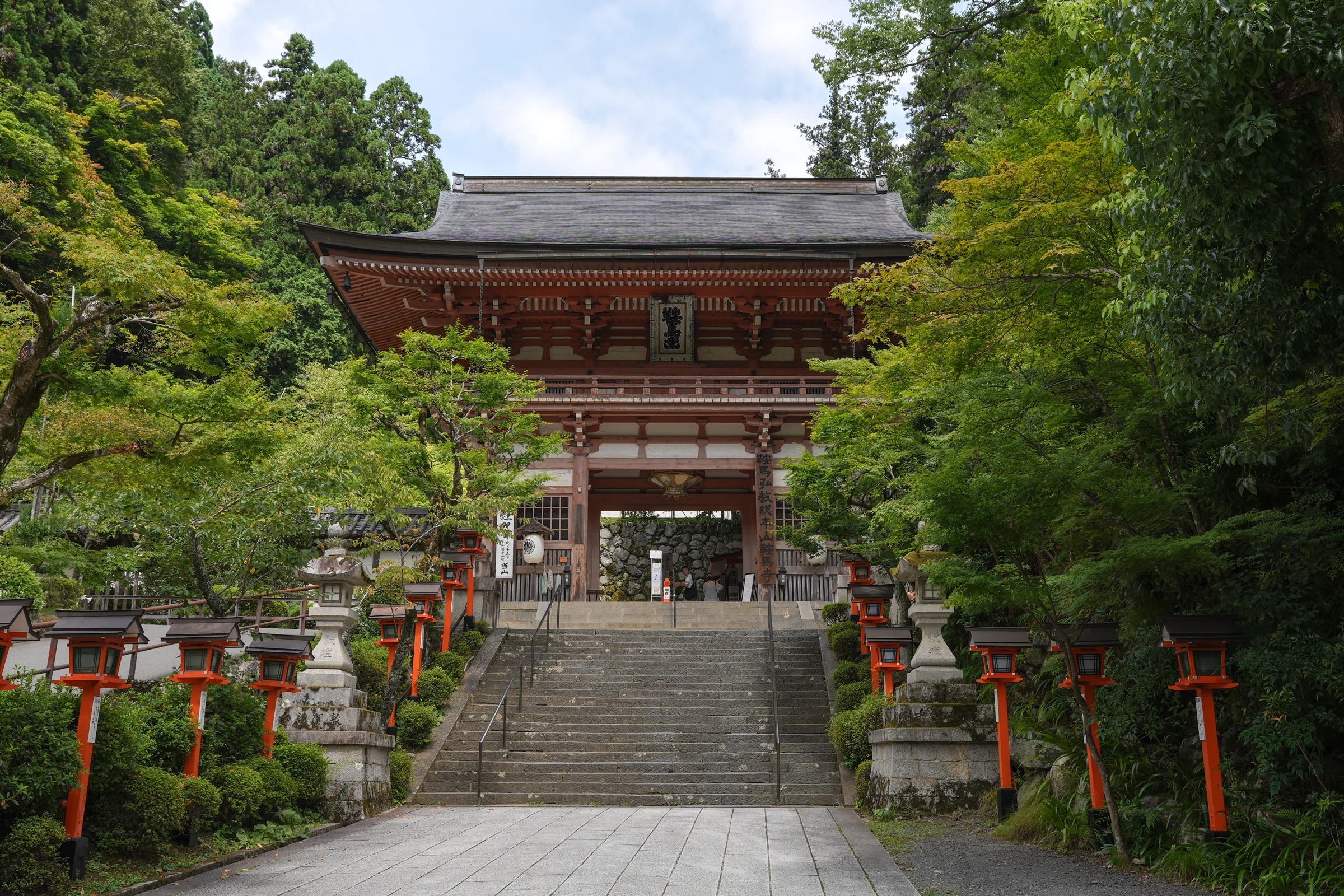 Kurama-dera Temple's Romon Gate framed by mountain greenery.
