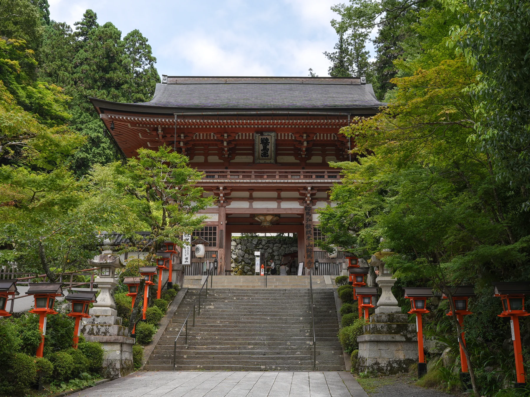 Kurama-dera Temple's Romon Gate framed by mountain greenery.